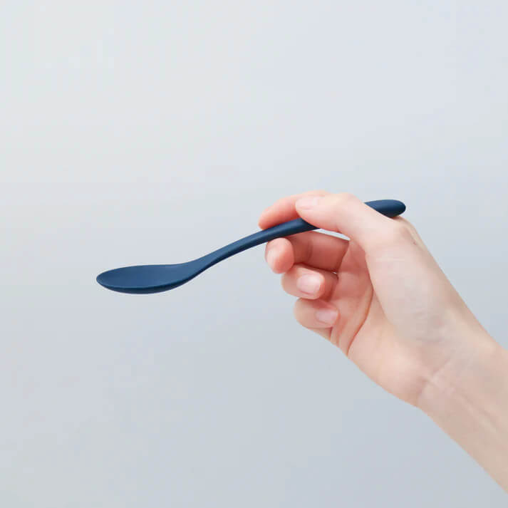 シンプルな青いスプーンを持つ手